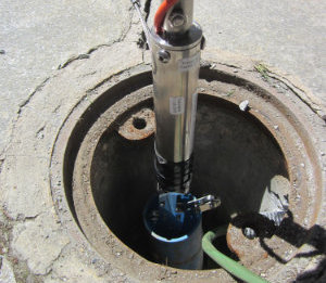 Installation of the In-Place-Inclinometer by Keynes Controls. Image depicting its lowering into a borehole using the Sensor Deployment Top Cap.